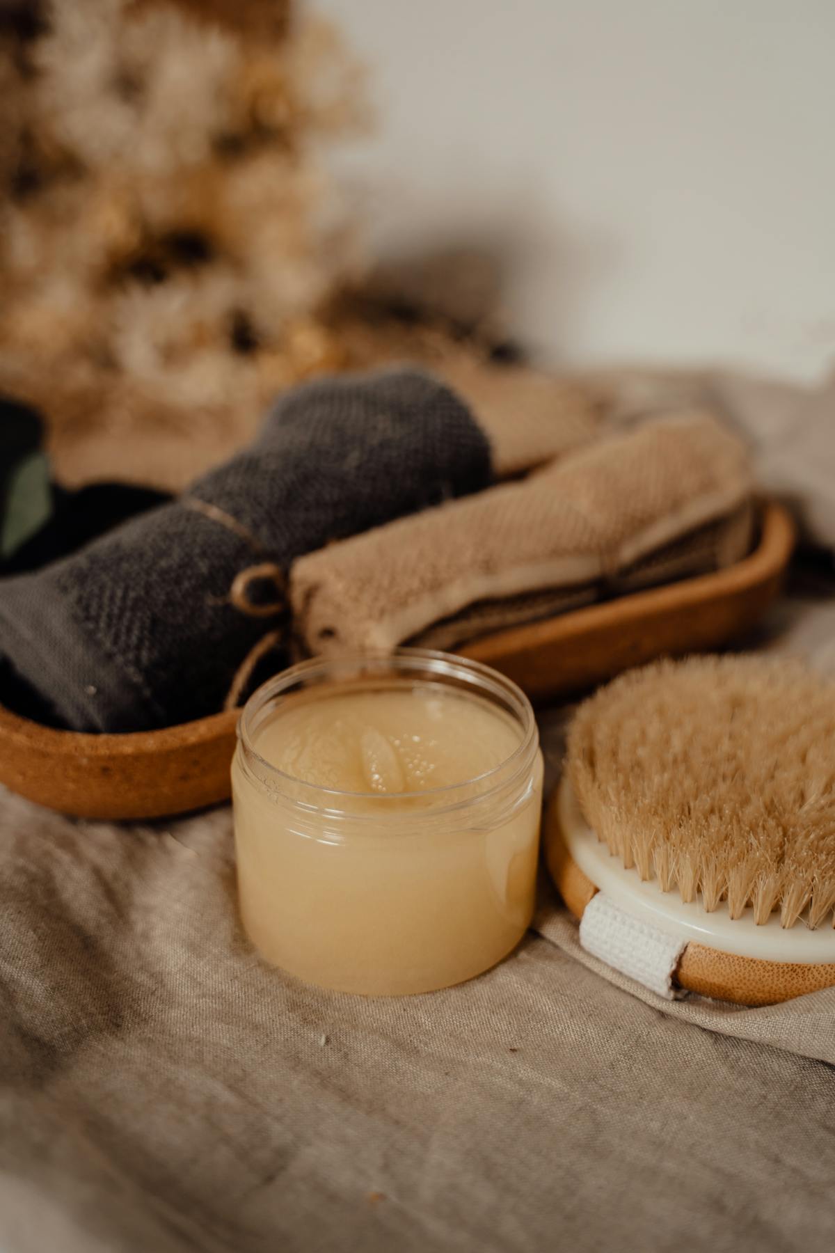 Pacific sea salt body scrub in a glass jar with dry brush on linen